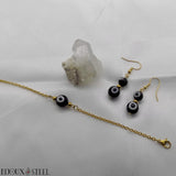 Boucles d'oreilles pendantes et bracelet dorés à perles noires et blanches mauvais oeil et acier inoxydable