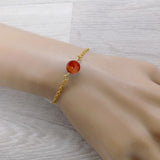 Bracelet en acier doré et sa perle d'agate rouge teintée