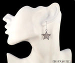 Création boucles d'oreilles pendantes à étoiles argentées serties de strass blancs sur présentoir