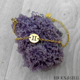 Bracelet signe du zodiaque des gémeaux argenté en acier chirurgical sur son présentoir agate grappe de raisin