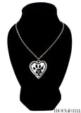 Création collier à pendentif cœur argenté et son empreinte de patte noire sur présentoir